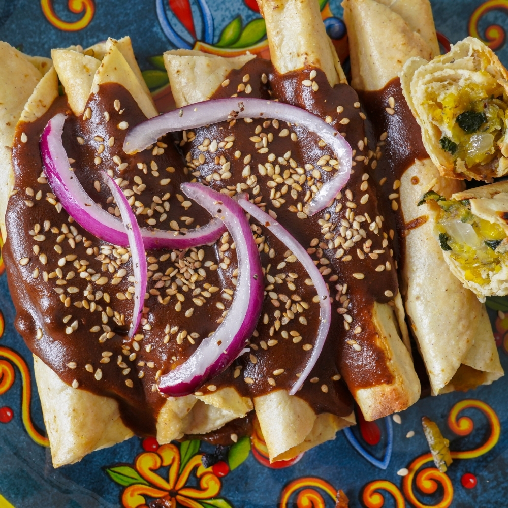 Tacos dorados de plátano macho con mole poblano