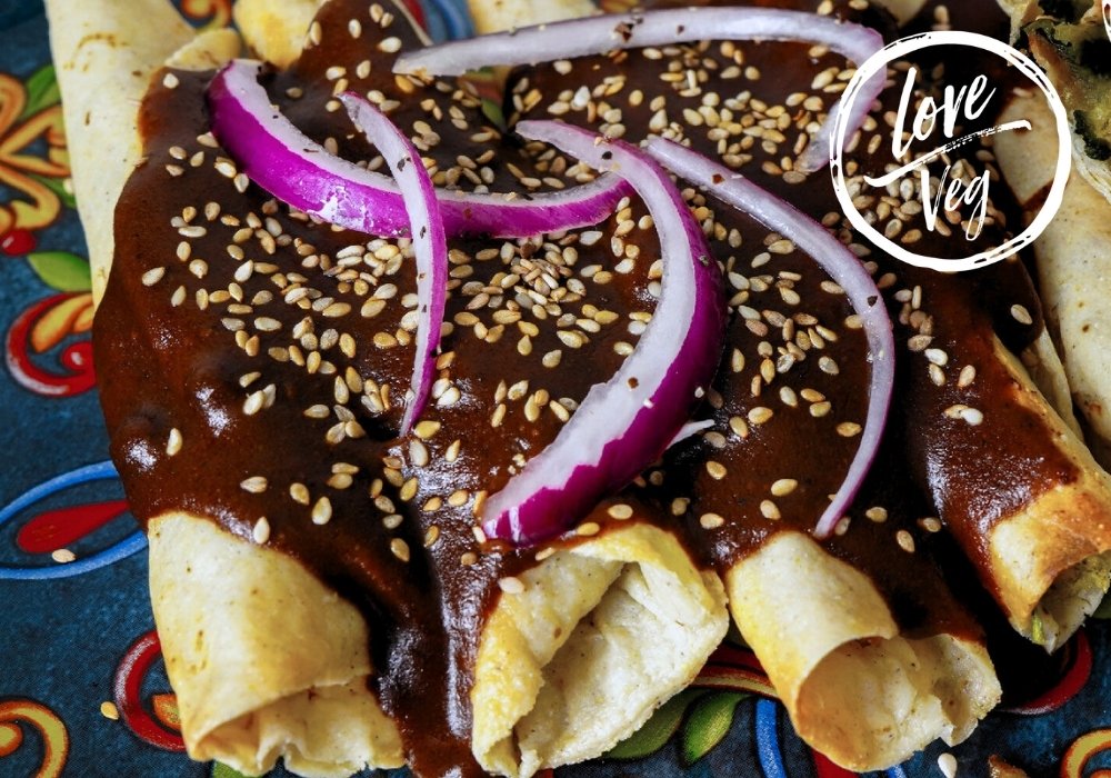 Mole poblano oscuro servido en un plato hondo, con textura espesa y brillante, listo para usar como relleno de tamales o acompañar platillos mexicanos.