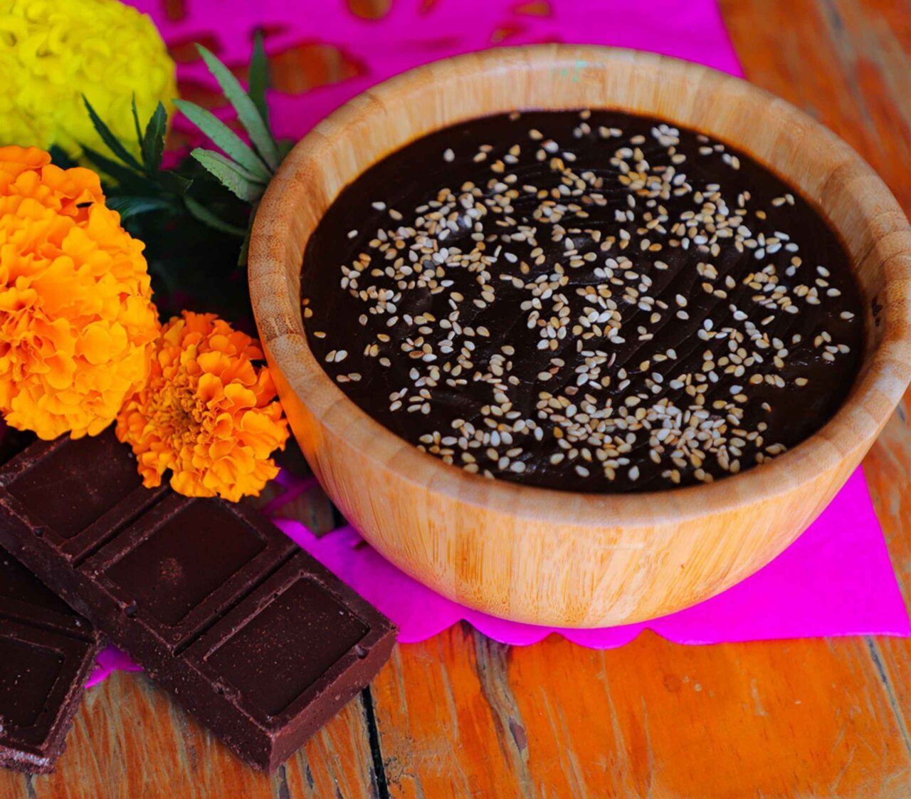 Mole poblano oscuro servido en un plato hondo, con textura espesa y brillante, listo para usar como relleno de tamales o acompañar platillos mexicanos.