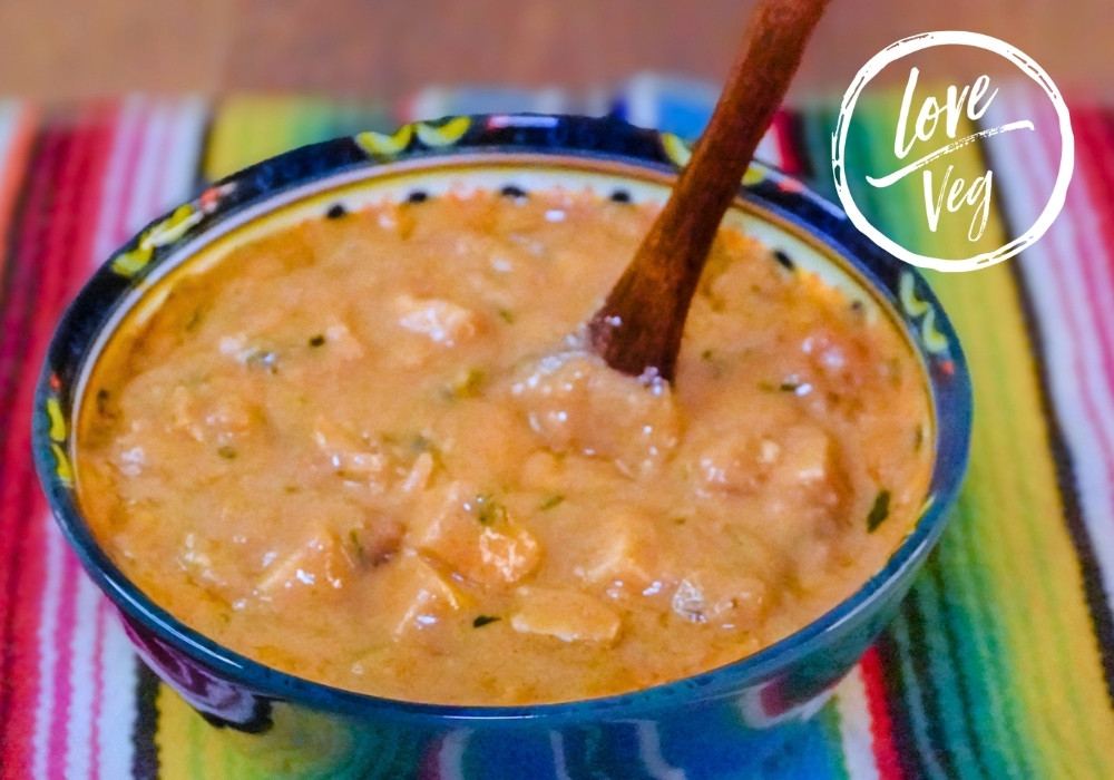 Salsa de maní ecuatoriana cremosa con tofu en tazón artesanal azul.