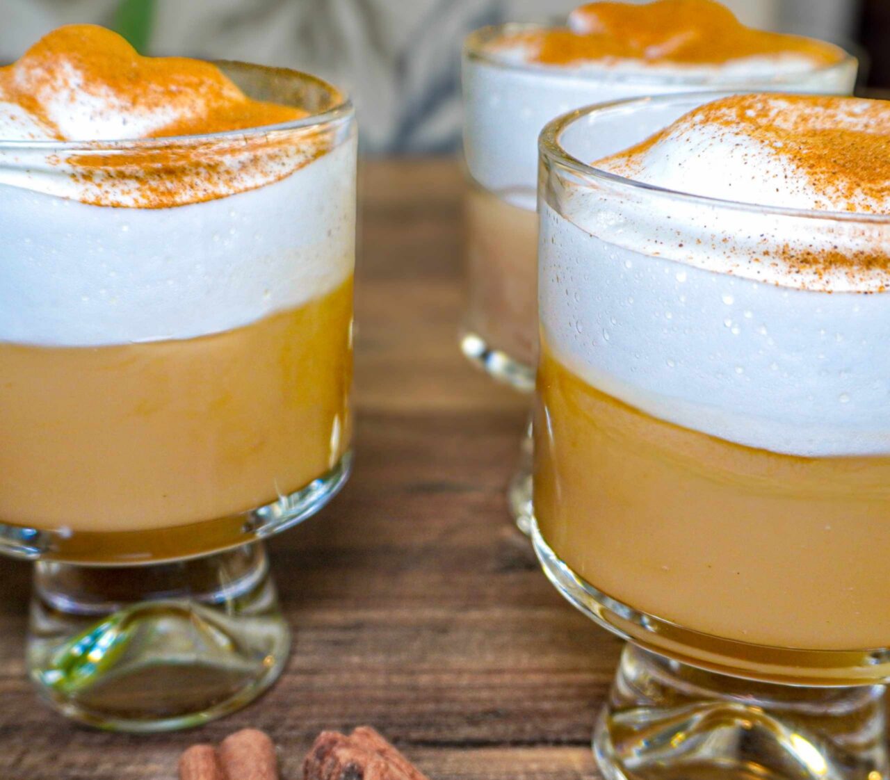 Copa de suspiro limeño vegano con una base de manjar blanco cremoso hecho a base de leches vegetales, coronado con un merengue vegano de aquafaba espolvoreado con canela molida.