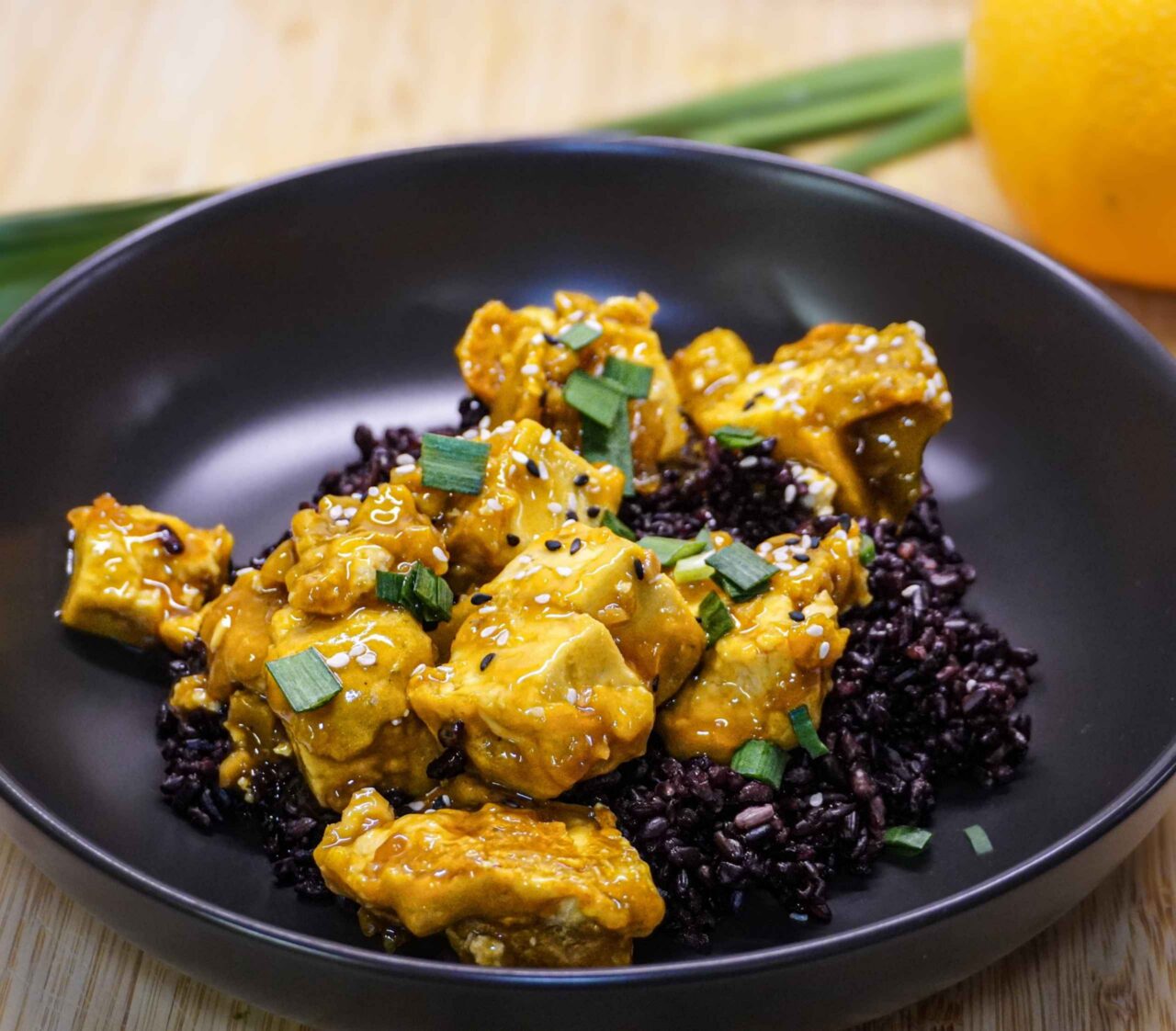 Tofu a la naranja agridulce estilo oriental con ajonjolí y cebollín fresco.